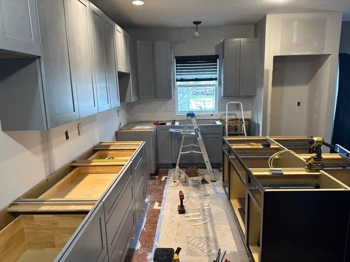Remodeled kitchen with white cabinets, island, and stainless appliances