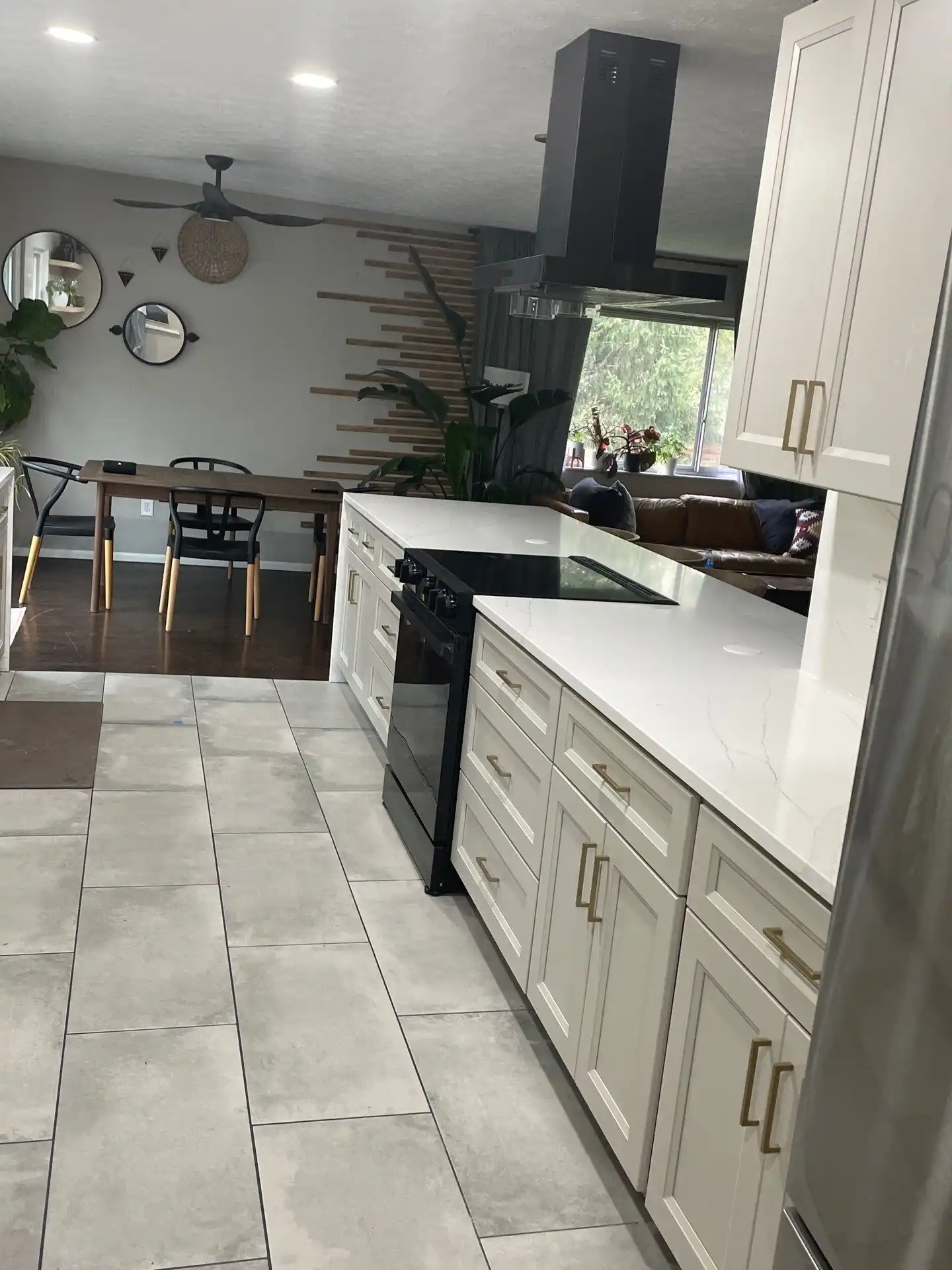 Remodeled kitchen with island, pendant lights, and white cabinets